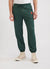 Forest green trackpants with orange octopus embroidery on left thigh