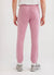 Pink trackpants with blue octopus embroidery on left thigh seen from back