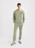 Pistachio green trackpants with orange octopus embroidery on left thigh, styled with matching pistachio green sweatshirt