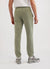 Pistachio green trackpants with orange octopus embroidery on left thigh, seen from back
