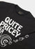 close up of black long sleeve t shirt with white print of cartoon snail and text "quite pricey"