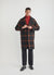 black wide leg trousers styled with black loafers, a rust roll neck and a black and brown wool trench coat